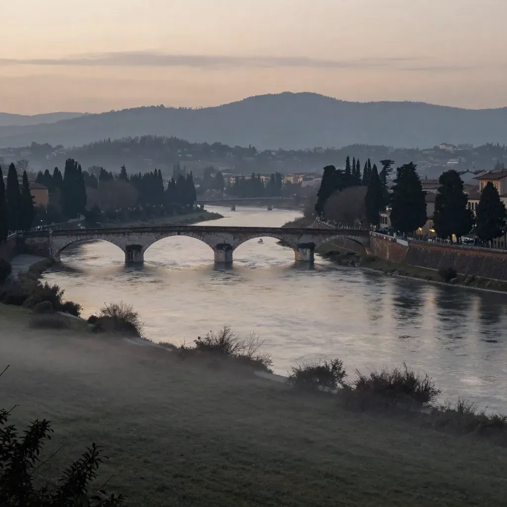 Veduta del fiume a Verona al tramonto, con ponte in pietra e cipressi nella foschia
